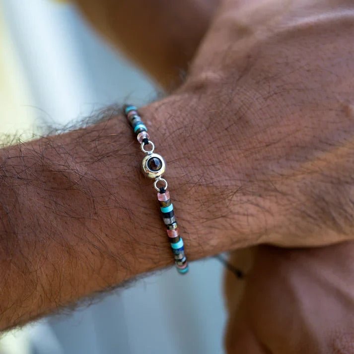 Bracelet fin en pierres heishi turquoise et noires avec pendentif photo rond argenté, style épuré et naturel.