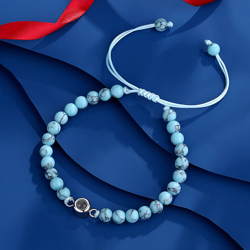 Bracelet ajustable en pierres turquoise blanche avec perle photo ronde et nœud coulissant blanc.