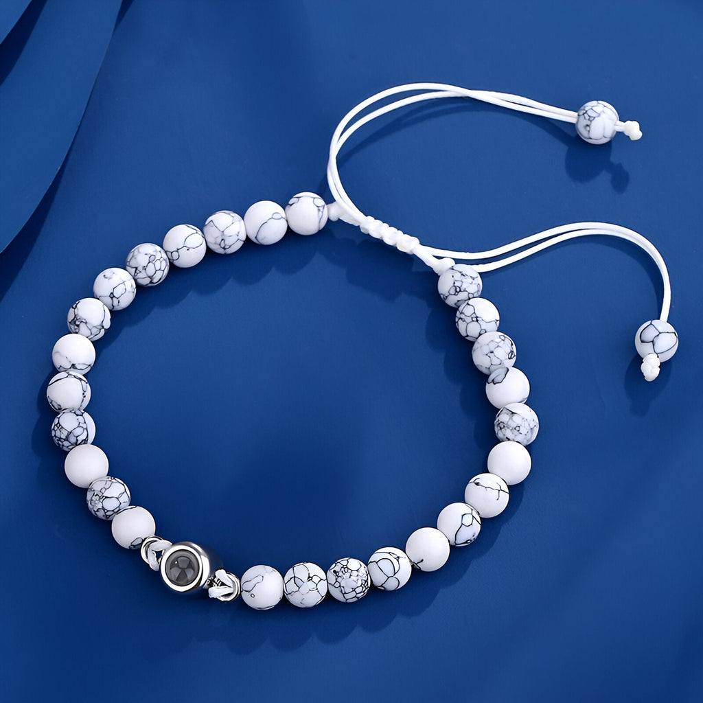 Bracelet blanc en pierres naturelles avec perles marbrées et breloque photo ronde en métal argenté.