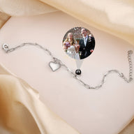 Bracelet photo personnalisé en titane argenté avec charm cœur ajouré et chaîne fine.