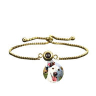 Bracelet photo personnalisé en titane or avec médaille ronde et photo de chien blanc souriant.