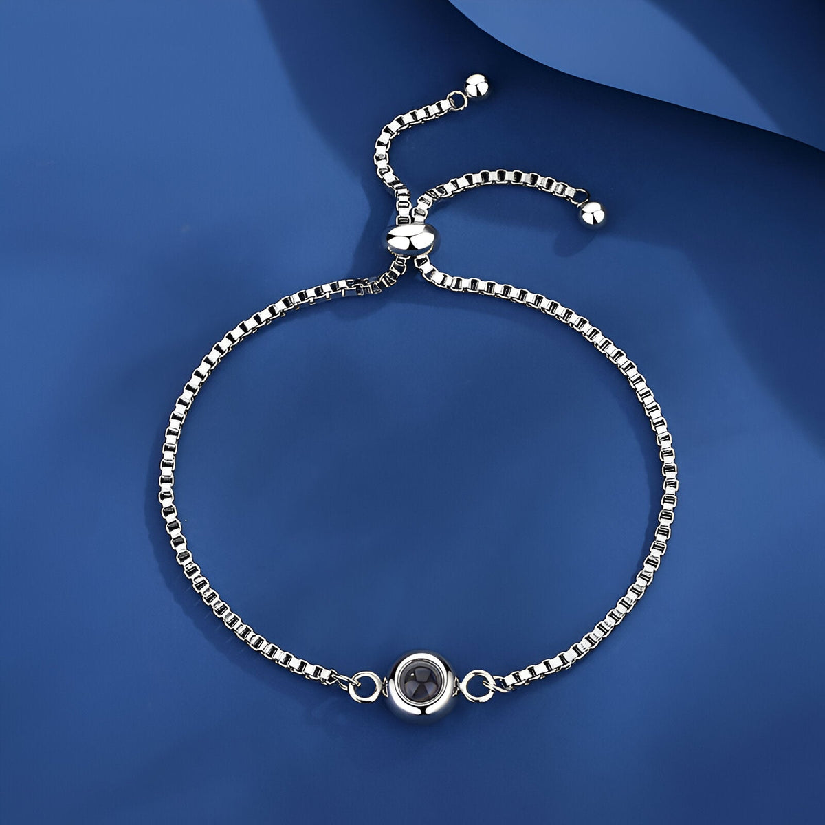 Bracelet en titane argenté avec médaille photo ronde personnalisable et fermoir coulissant ajustable.