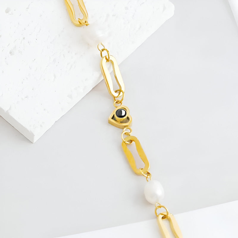 Bracelet en titane doré avec perle d'eau douce et pendentif cœur gravé d'une photo.
