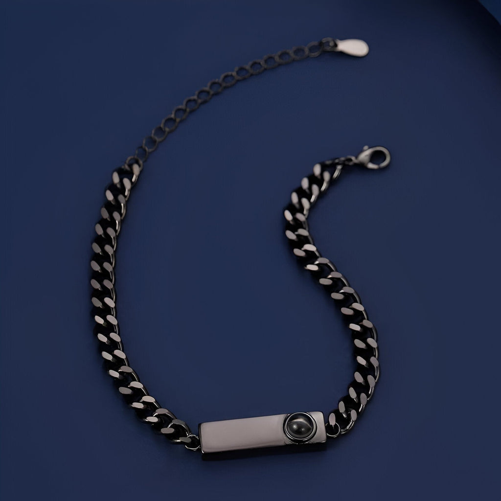 Bracelet gourmette en titane noir avec plaque gravée et chaîne épaisse à maillons larges.