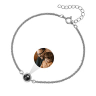 Bracelet en acier inoxydable argenté avec médaille ronde personnalisée et projection photo intégrée, fermeture ajustable.