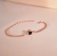 Bracelet fin en acier inoxydable plaqué or rose avec projection photo circulaire au centre.