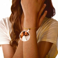 Bracelet fin en acier inoxydable doré avec pendentif photo circulaire lumineux, porté au poignet.