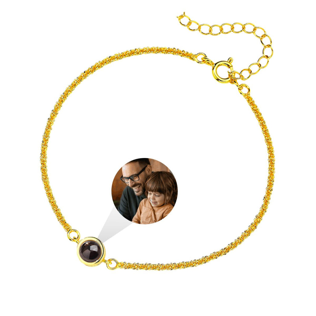 Bracelet fin en acier inoxydable doré avec pendentif circulaire à projection photo personnalisée.