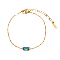 Bracelet fin en titane doré avec pierre rectangulaire bleu clair et chaîne ajustable.