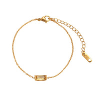 Bracelet fin en titane doré avec pierre rectangulaire jaune et chaîne ajustable.