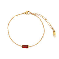 Bracelet fin en titane doré avec pierre rectangulaire rouge et chaîne ajustable.