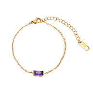 Bracelet fin en titane doré avec pierre rectangulaire violette et chaîne ajustable.