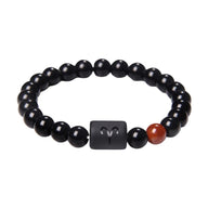 Bracelet perles de verre noir avec perle rouge et symbole astrologique gravé en noir mat.