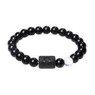 Bracelet noir en perles de verre rondes avec un lien carré gravé du symbole astrologique Balance et une perle blanche irisée