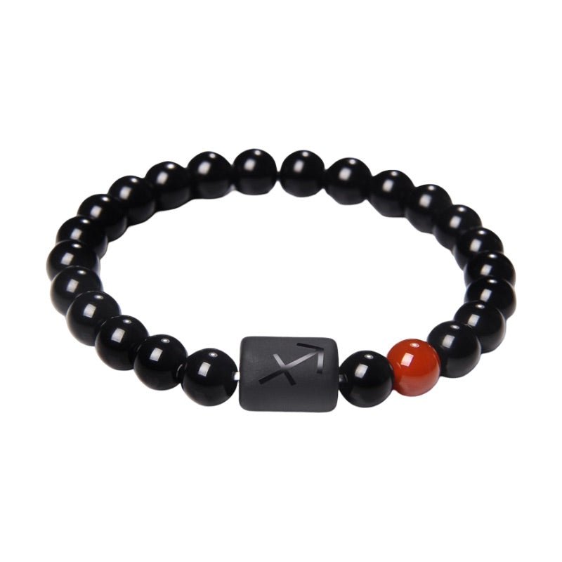 Bracelet composé de perles de verre noir rondes avec une perle plate gravée du symbole astrologique Sagittaire et une perle.