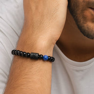 Bracelet homme perles de verre noir mat avec perle bleue et symbole astrologique gravé sur perle centrale noire brillante.
