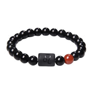 Bracelet élastique perles rondes en verre noir avec perle rouge et carré noir gravé du symbole astrologique Lion.