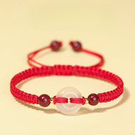 Bracelet femme en fil rouge ciré tressé avec pierre de jade blanche centrale et deux pierres de cinabre bordeaux.