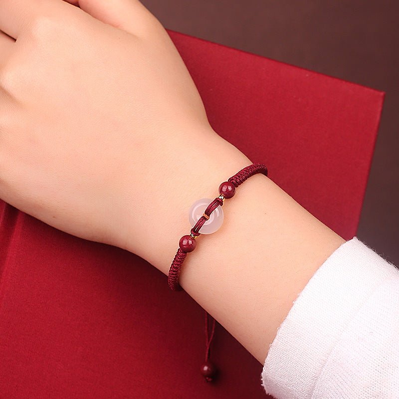 Bracelet Lima bordeaux en fil ciré avec pierres de cinabre et un jade translucide rond.