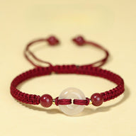 Bracelet femme fil ciré bordeaux tressé avec perles de cinabre et pierre de jade blanche centrale.
