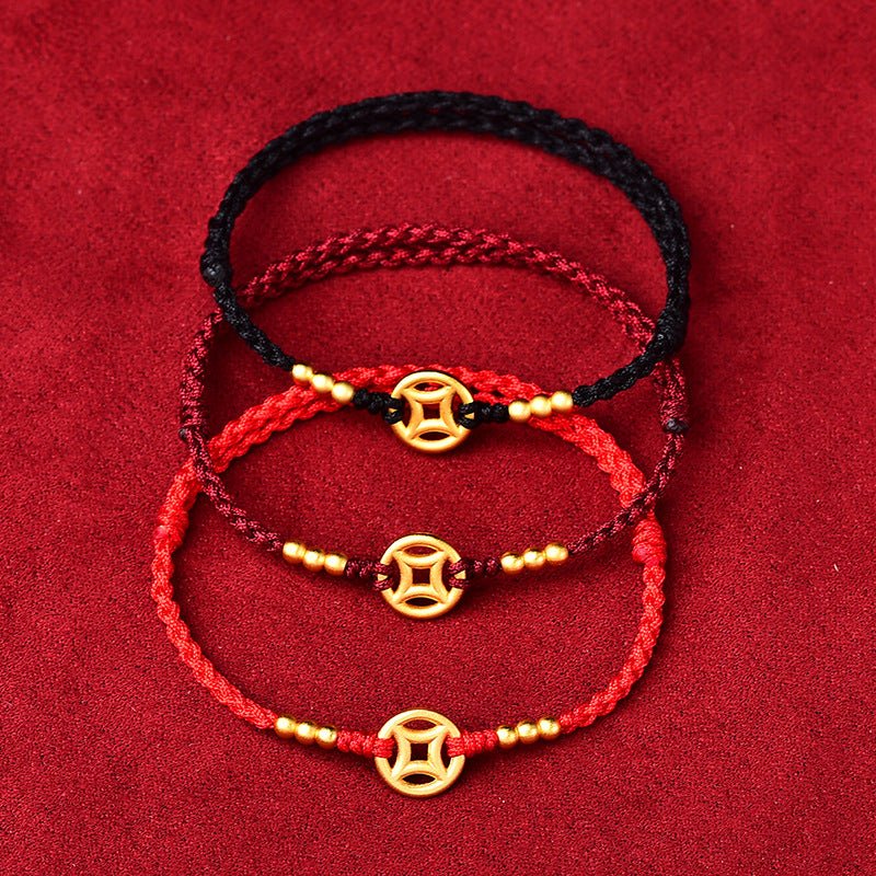 Trois bracelets en fil rouge, bordeaux et noir avec charms dorés et tissage fin.