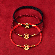 Trois bracelets en fil rouge, bordeaux et noir avec charms dorés et tissage fin.
