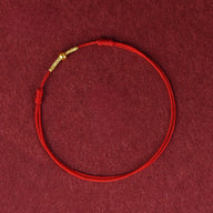 Bracelet en fil rouge nylon avec fermoir doré, style minimaliste et ajustable.