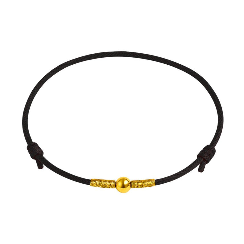 Bracelet porte-bonheur en nylon noir avec perle dorée centrale et fermoirs assortis.