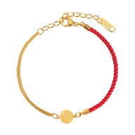 Bracelet femme en fil rouge tressé et chaîne titane doré avec médaille gravée circulaire.