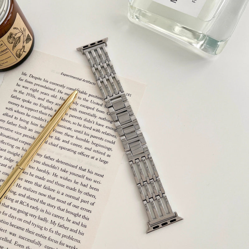 Bracelet pour Apple Watch en métal argenté avec maillons élégants et fermeture déployante.