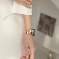 Bracelet pour Apple Watch or rosé en métal chic avec maillons larges porté au poignet féminin.