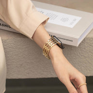 Bracelet doré chic à maillons pour Apple Watch porté au poignet, style soirée élégant.