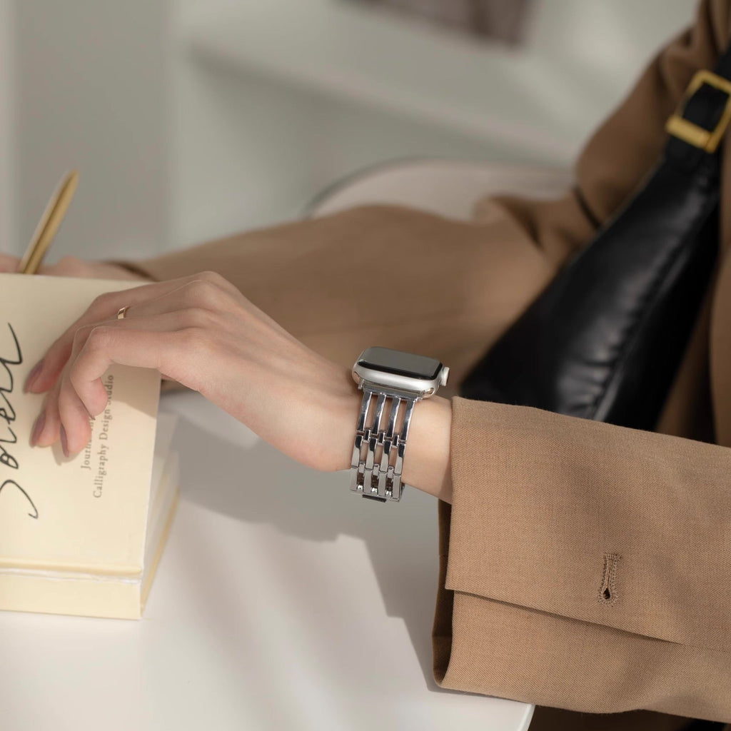 Bracelet en mailles argentées pour Apple Watch, style élégant et moderne, porté au poignet féminin.