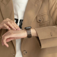 Bracelet Apple Watch noir en maille métallique élégante porté avec veste beige chic.