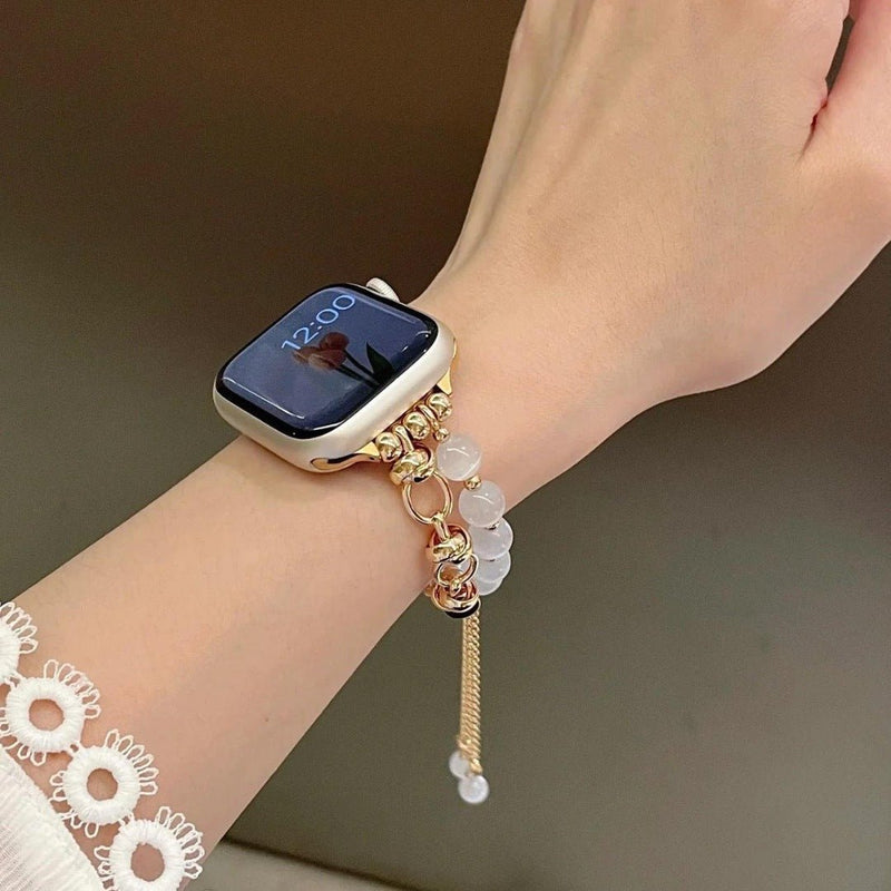 Bracelet Apple Watch perles œil de chat blanc et or rosé avec chaîne ajustable élégante.