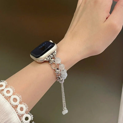 Bracelet pour Apple Watch en perles œil de chat blanches avec détails argentés et chaîne ajustable élégante.
