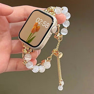 Bracelet pour Apple Watch en perles œil de chat blanches avec détails dorés et fermoir réglable.