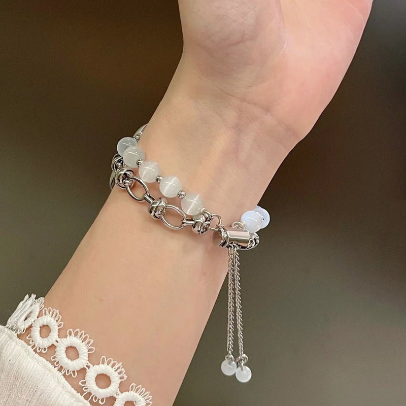 Bracelet ajustable en perles œil de chat blanches avec chaînes argentées élégantes.