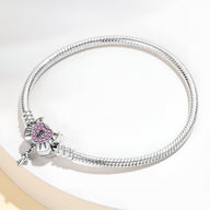 Bracelet serpent argent avec charm cœur cadenassé orné de pierres roses, style élégant.