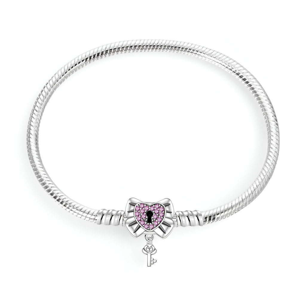 Bracelet argenté pour charm avec pendentif cœur cadenassé orné de pierres violettes et clé pendante.