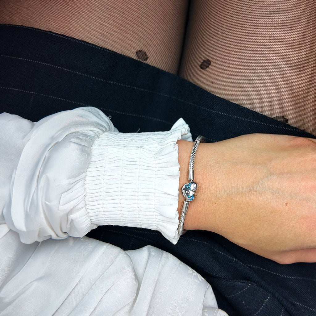 Bracelet argenté fin avec charms en forme de cœur et papillons, style délicat et personnalisable.