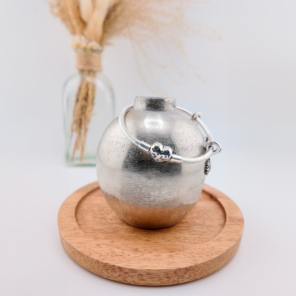 Bracelet argenté fin pour charm avec pendentifs cœur et papillons, style élégant et délicat.