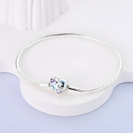 Bracelet argenté fin pour charms avec fermoir cœur orné de papillons bleus et violets.