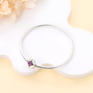 Bracelet argent fin avec charm carré orné de pierres violettes et rose pâle.