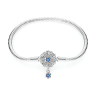 Bracelet argent serpent avec charm fleur et pendentif étoile bleue élégante.