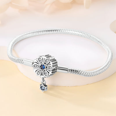 Bracelet argenté serpent avec charm fleur orné d’un saphir bleu et pendentif goutte bleu.