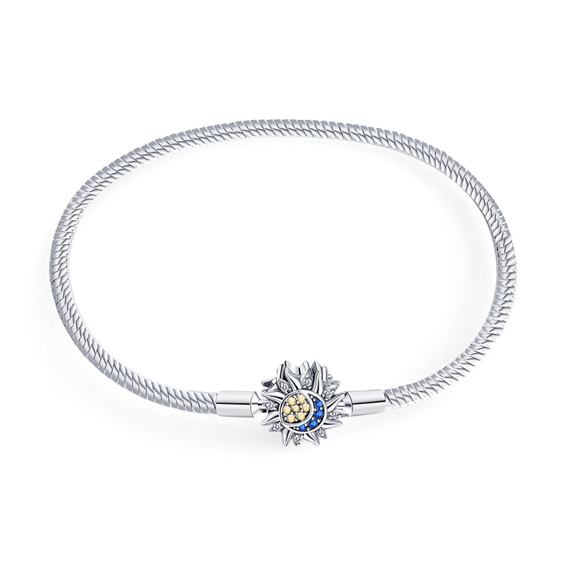 Bracelet chaîne serpent argent avec pendentif soleil ouvragé et pierre bleue au centre.