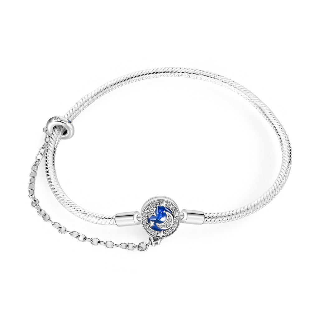 Bracelet serpent argenté avec charm rond bleu nuit étoilée et chaîne de sécurité fine.
