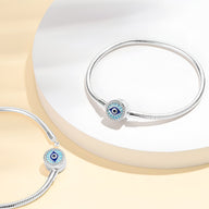 Bracelet en argent avec charm œil de protection bleu, style serpent, finition lisse et élégante.