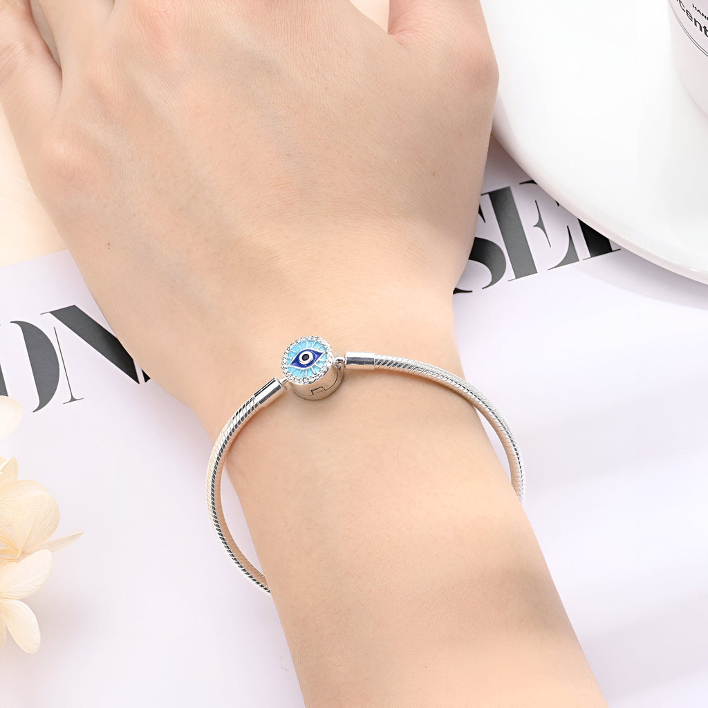Bracelet argenté fin avec charm œil bleu protecteur, style minimaliste élégant pour femme.